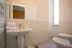 La salle de bains blanche est pourvue d'un lavabo et de toilettes. dans l'établissement Colosseo Apartments and Rooms - Rome City Centre, à Rome