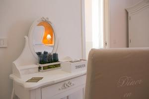 une coiffeuse blanche avec un miroir et une chaise dans l'établissement Colosseo Apartments and Rooms - Rome City Centre, à Rome