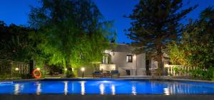 a swimming pool in front of a house at night at Villa Eleonora in Rhodes Town