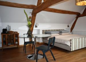 um quarto com uma cama, uma mesa e cadeiras em De Oude Limonadefabriek em Beek