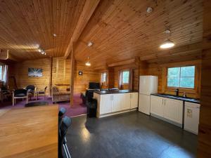a kitchen and living room in a log cabin at Avon Tyrrell Outdoor Activity Centre in Bransgore