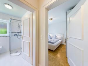 a bathroom with a shower and a bed in a room at BERG.ZEIT.LOS in Garmisch-Partenkirchen