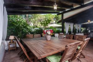 una sala da pranzo all'aperto con tavolo e sedie in legno di Villa Stella a Santa Margherita di Pula