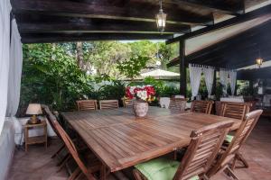 an outdoor dining room with a wooden table and chairs at Villa Stella in Santa Margherita di Pula