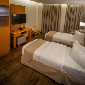 A bed or beds in a room at Sama Muscat Hotel