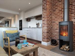 a living room with a fireplace and a brick wall at Seagrass Cottage in Southwold, Stunning Property with Views! in Southwold