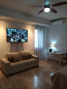 a living room with a couch and a tv on the wall at B&B Il Ponticello in Gualtieri