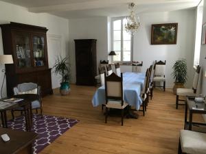 a dining room with a blue table and chairs at Maison d'Hôtes Lassaubatju in Hontanx