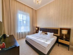 a bedroom with a large white bed and a window at Tiffi Old Town Hotel in Warsaw