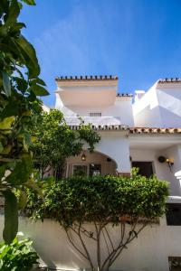 a white house with a hedge in front of it at A cozy and elegant townhouse across the beach in Torre de Benagalbón