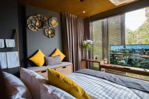 a bedroom with a bed and a large window at AKRA Collection Layan in Layan Beach