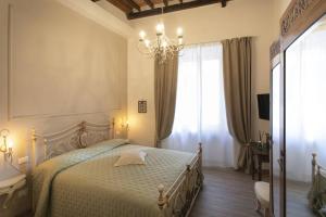 a bedroom with a bed with a chandelier and a window at Casa Mavì- Siena in Siena