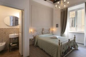 Casa Mavì- Siena في سيينا: غرفة نوم مع سرير وحوض استحمام ومغسلة
