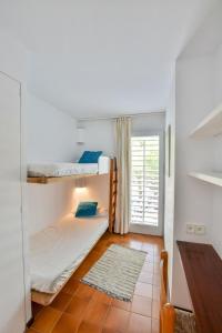 a room with two bunk beds and a table at CENTRIC APARTMENT CADAQUES -private parking - CA L'ELLA in Cadaqués