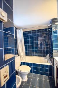 een blauwe betegelde badkamer met een toilet en een bad bij CENTRIC APARTMENT CADAQUES -private parking - CA L'ELLA in Cadaqués