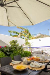 einen Tisch mit Teller mit Lebensmitteln darüber in der Unterkunft A cozy and elegant townhouse across the beach in Torre de Benagalbón