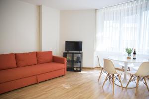uma sala de estar com um sofá e uma mesa em Estúdio Corujeira em Porto