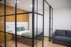 um quarto com uma cama e um sofá em Estúdio Corujeira em Porto
