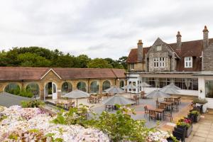 an outdoor courtyard with tables and chairs and umbrellas at The Caledonian Island Hotel in Sandown