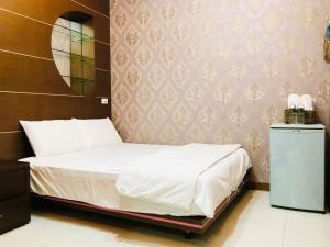 a bedroom with a bed and a wall at Jinye B&B 金夜民宿 in Xiaoliuqiu