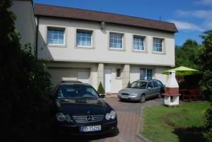two cars parked in front of a house at POKOJE & NOCLEGI de'Górska in Poznań