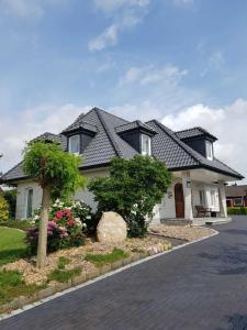 a white house with a black roof at Ferienhaus Gesine 25193 in Bunde