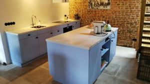 a kitchen with white cabinets and a counter top at La Vache Contente in Maastricht