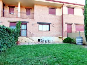 a house with chairs and a lawn in front of it at Casa San Miguel in Huércanos
