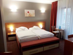a bed in a hotel room with two pillows at KATERAIN hotel, restaurace, wellness in Opava