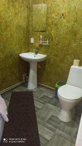 a bathroom with a white toilet and a sink at Бюджетне житло in Kunovka
