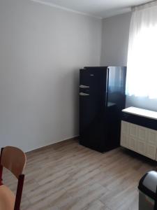 a kitchen with a black refrigerator and a table at Helga Apartman in Makó