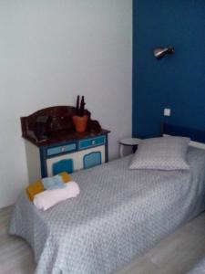 ein Schlafzimmer mit einem Bett und einer blauen Wand in der Unterkunft la dabinerie in Pruniers