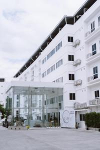 a large white building with a glass facade at Thewhitehotel BY Charoensri - SHA Extra Plus in Udon Thani