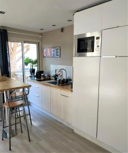 een keuken met een witte koelkast en een tafel bij Charmant appartement à 350m de la plage et du port in Fréjus
