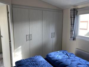 een slaapkamer met een blauw bed en een raam bij RBR 722 - Beach Resort Kamperland in Kamperland