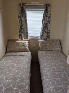 a small bedroom with two beds and a window at Cozy Holiday Home in Anderby Creek in Anderby