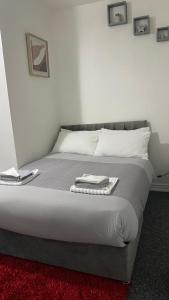 ein Schlafzimmer mit einem Bett mit zwei Handtüchern darauf in der Unterkunft bvapartments-Blackhouse in Huddersfield