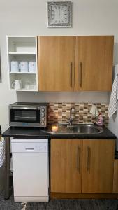 a kitchen with a sink and a microwave at bvapartments-Blackhouse in Huddersfield