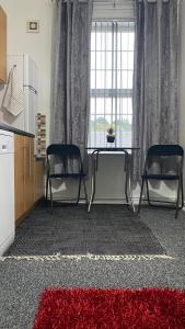 a living room with two chairs and a table and a red rug at bvapartments-Blackhouse in Huddersfield