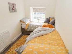 two beds in a small room with a window at Manor House Farm Cottage in Saltburn-by-the-Sea