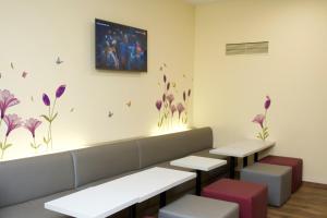a waiting room with benches and flowers on the wall at Colour Hotel in Frankfurt/Main