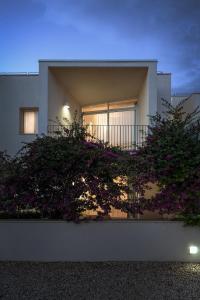 a house with a balcony with purple flowers at Cala Palme Lampedusa in Lampedusa