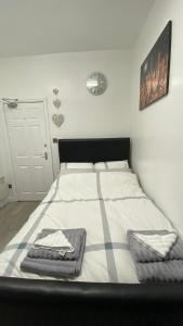 een slaapkamer met een bed met twee handdoeken erop bij bvapartments-Queensgate 2 in Huddersfield
