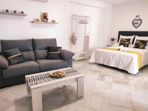 un soggiorno con un divano e un letto di Loft Sherry a Jerez de la Frontera