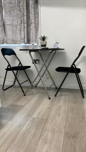 una mesa y 2 sillas en una habitación con suelo de madera en bvapartments-Queensgate 2, en Huddersfield