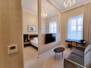 a living room with a couch and a bed and a television at Tiffi Old Town Hotel in Warsaw