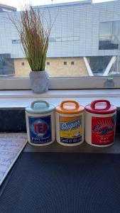 three cans of tea sitting on a shelf next to a window at bvapartments-Queensgate 2 in Huddersfield