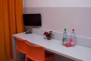 un tavolo con due bottiglie sopra e sedie arancioni di Colour Hotel a Francoforte sul Meno