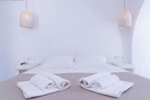 ein weißes Schlafzimmer mit weißen Handtüchern auf dem Bett in der Unterkunft Naxos Sandastic in Agios Prokopios