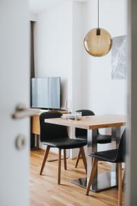 mesa de comedor con sillas negras y mesa de madera en Parks 73 The Townhouse Hotel en Viena